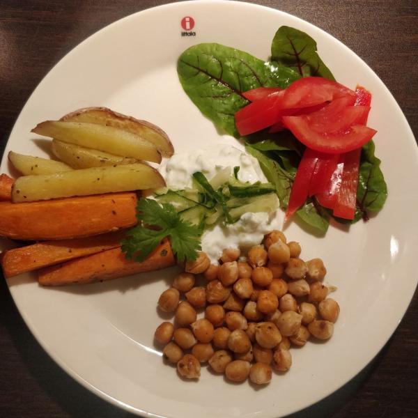 roasted veggies with yogurt sauce in the center, lettuce and tomato salad on the top-right, and chickpeas in the bottom